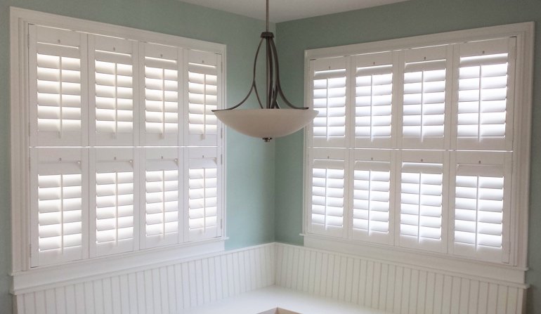 Pastel green wall in Orlando kitchen with shutters.